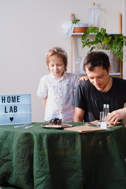 Foto padre e hijo experimentando en el laboratorio doméstico y estudiando las propiedades químicas