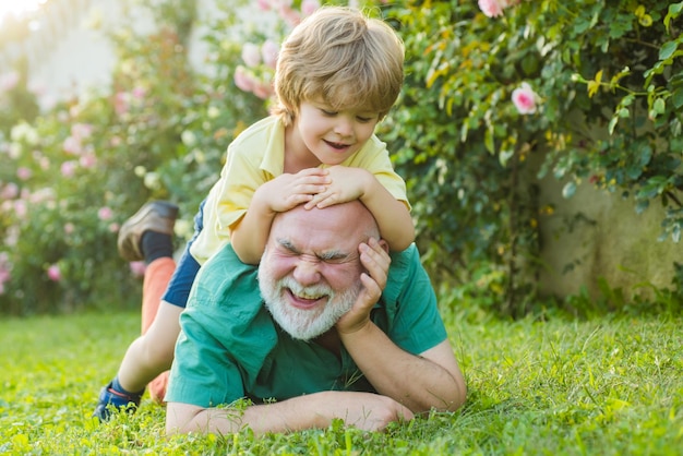 Padre e hijo de familia feliz en el prado con una cometa en el verano en la hierba verde abuelo e hijo