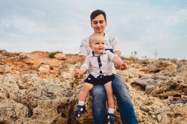 Padre e hijo. La familia pasea por la playa pedregosa junto al mar.