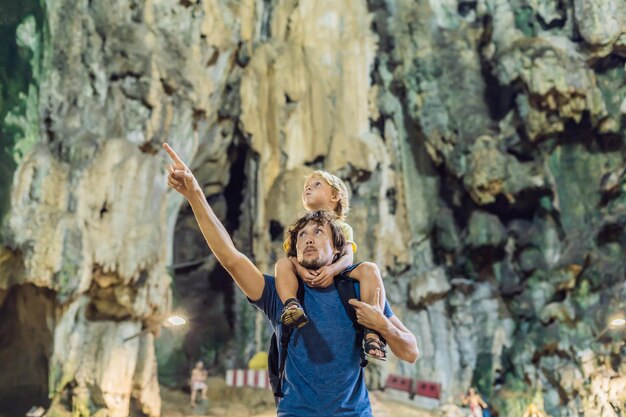 Foto padre e hijo en el fondo de las cuevas de batu, cerca de kuala lumpur, malasia. viajar con el concepto de niños