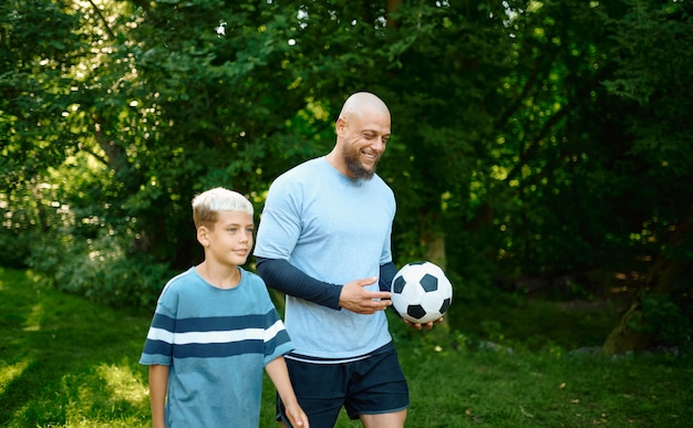 Padre e hijo juegan al fútbol en un día soleado