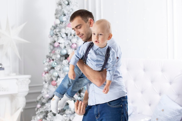 Padre e hijo juegan contra el fondo de un árbol de Navidad Hombre e hijo en el nuevo año