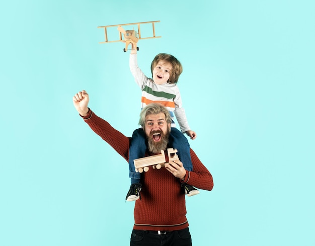 Padre e hijo jugando con avión de madera