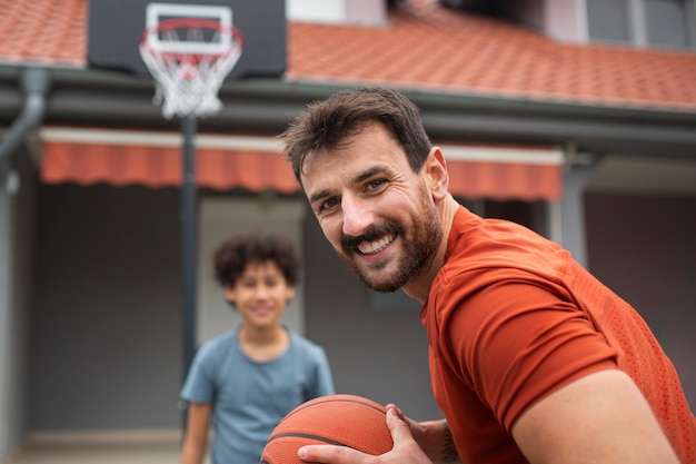 Padre e hijo jugando baloncesto juntos en el patio trasero