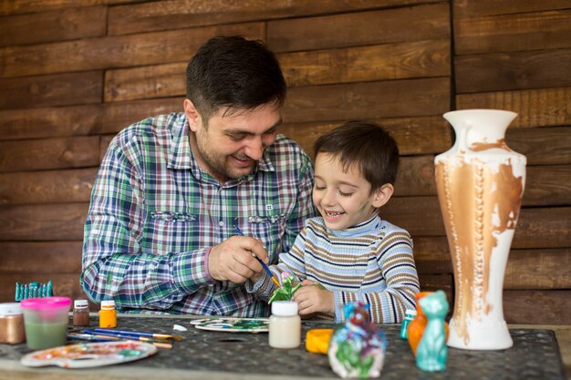 Padre e hijo jugando con colores de pintura