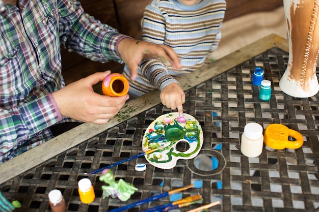 Padre e hijo jugando con colores de pintura