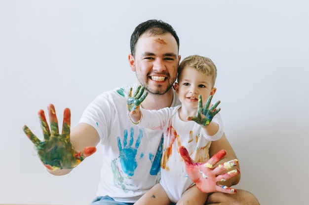 Padre e hijo jugando con colores de pintura