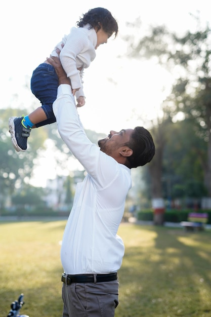 Padre e hijo jugando en el parque al atardecer