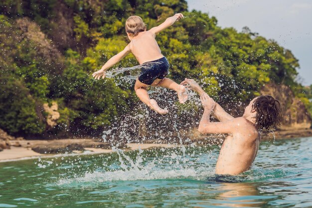 Padre e hijo jugando en la playa durante el día