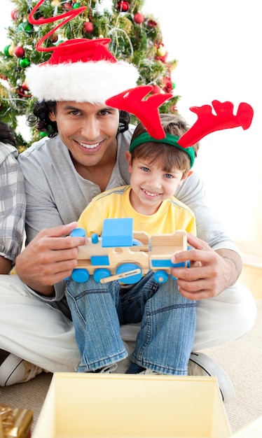 Padre e hijo jugando con un regalo de Navidad