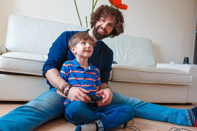 Padre e hijo jugando videojuegos en casa