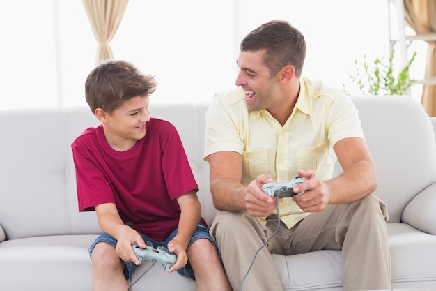 Padre e hijo jugando videojuegos en casa