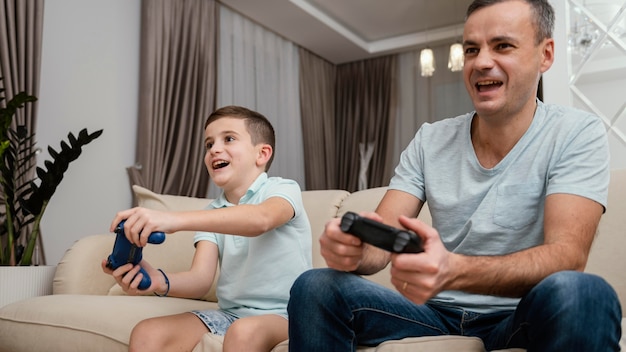 Foto padre e hijo jugando videojuegos