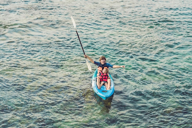 Padre e hijo en kayak en el océano tropical.