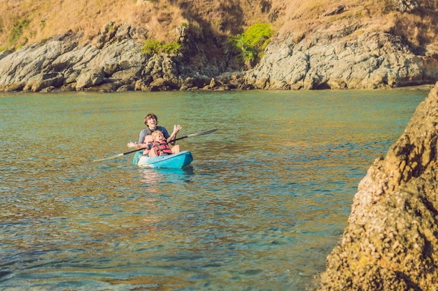 Padre e hijo en kayak en el océano tropical.