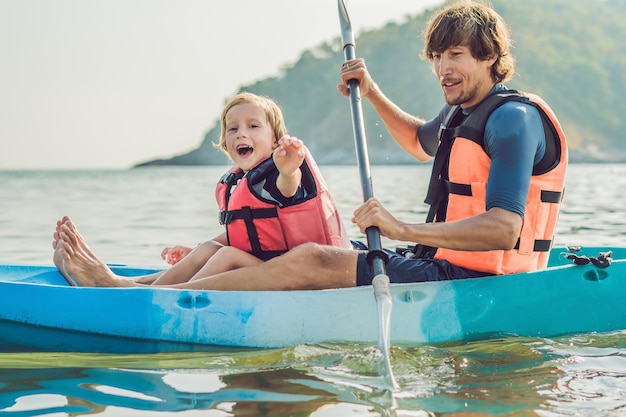 Padre e hijo en kayak en el océano tropical.