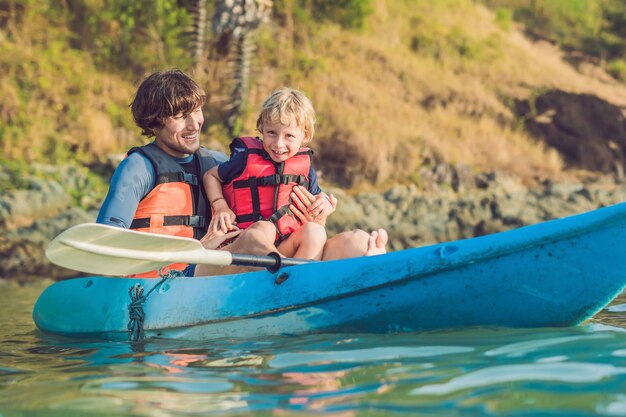 Padre e hijo en kayak en el océano tropical.