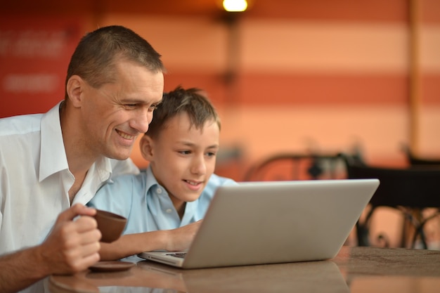 Padre e hijo con laptop en la mesa
