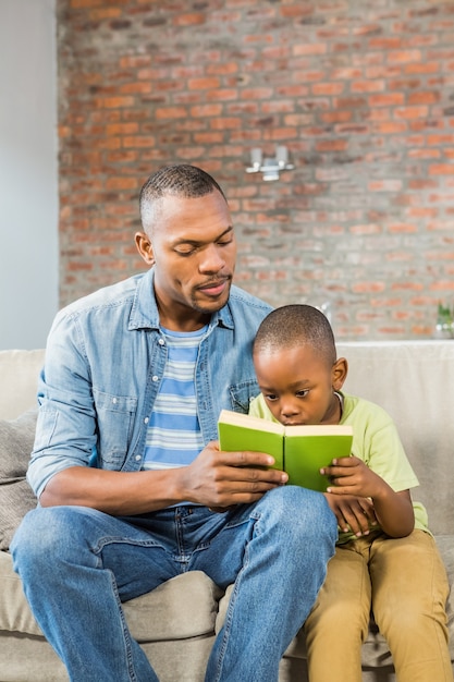 Padre e hijo leyendo en el sofá