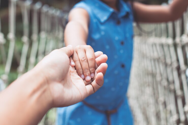 Foto padre e hijo de la mano juntos mientras camina sobre el puente de cuerda colgante