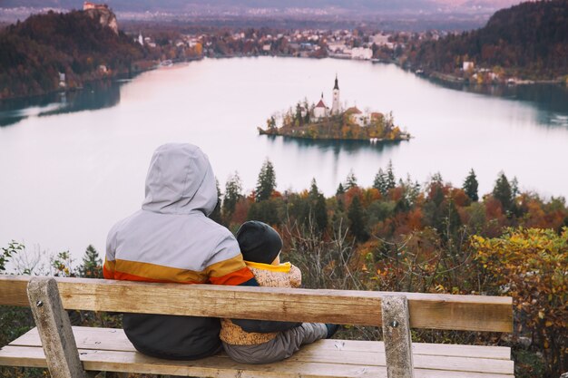 Padre e hijo mirando el atardecer con una vista increíble sobre el lago Bled en otoño o invierno en Eslovenia Europa