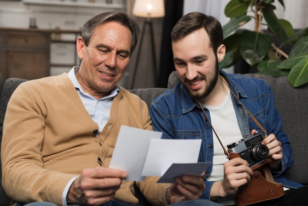 Foto padre e hijo mirando fotos