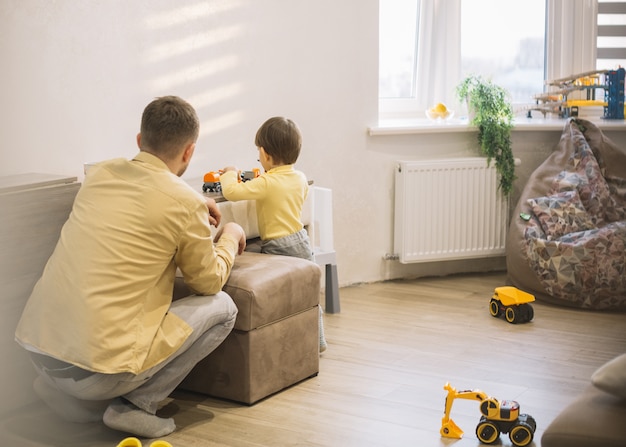 Foto padre e hijo en una moderna sala jugando