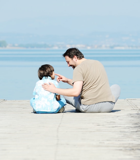 Padre e hijo en el muelle en un hermoso lago