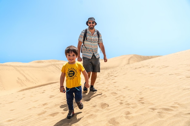 Padre e hijo muy felices en las dunas de Maspalomas Gran Canaria Islas Canarias