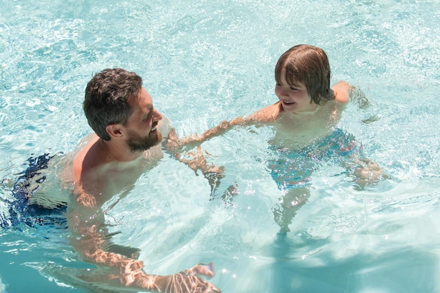 Padre e hijo nadando en la piscina ocio familiar de verano padre e hijo en la piscina lecciones de natación ho...