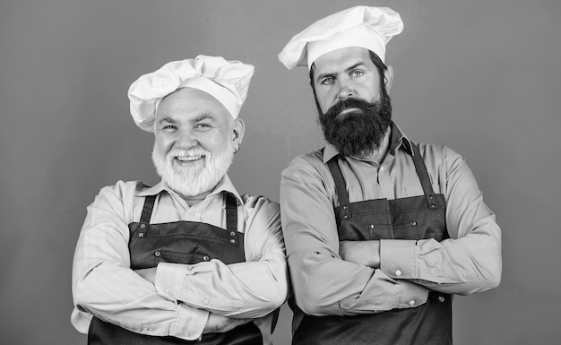 Padre e hijo, pasatiempo culinario, hombres maduros con barba, cocineros profesionales de restaurantes, chefs, hombres, usan delantales, restaurante familiar, trabajadores de café, cocina de restaurante, industria culinaria, personal de restaurante.