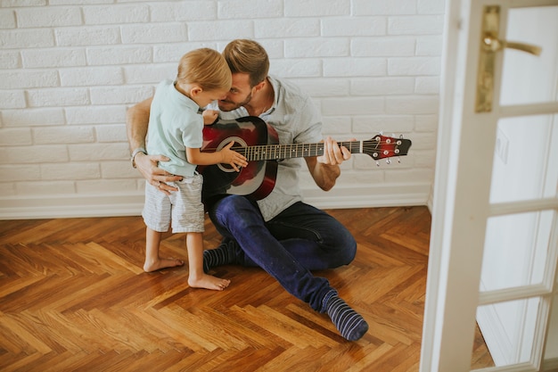 Padre e hijo pequeño con guitarra.