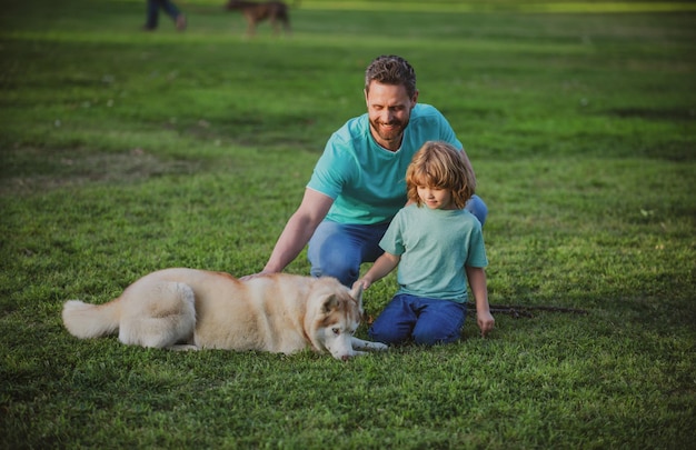 Padre e hijo con perro en el concepto de estilo de vida familiar feliz del parque