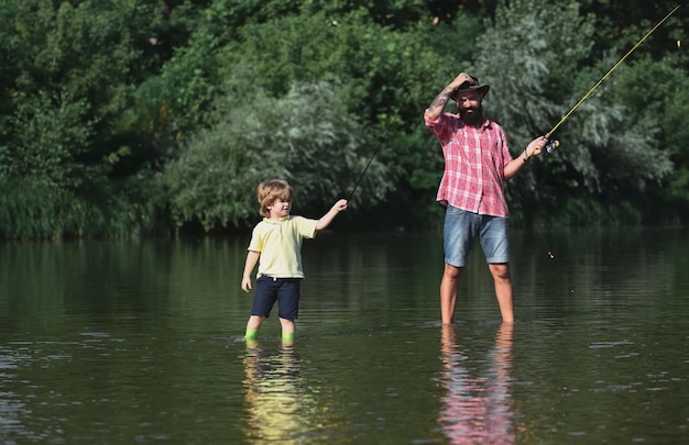 Padre e hijo pescando padre con su hijo en el río disfrutando de la pesca con cañas de pescar