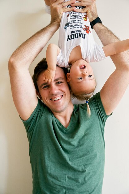 Foto padre e hijo de pie contra la pared