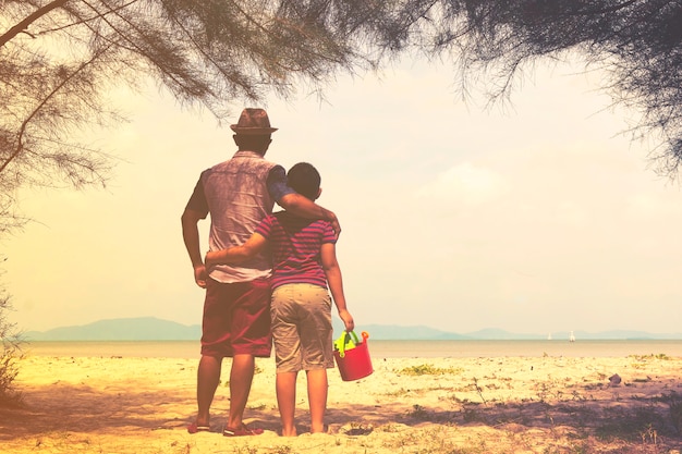 Padre e hijo con la playa o la familia con la playa.