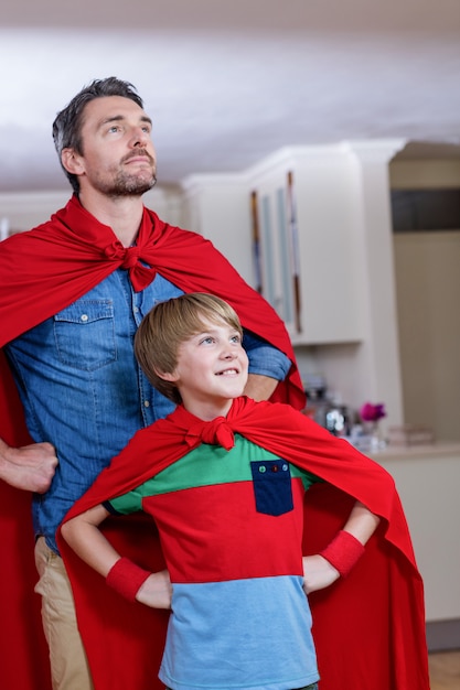 Padre e hijo que fingen ser superhéroes en la sala de estar