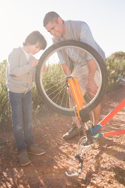 Padre e hijo, reparar bicicleta juntos