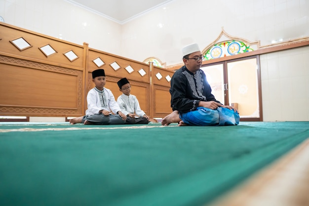 Foto padre e hijo rezando juntos en la mezquita