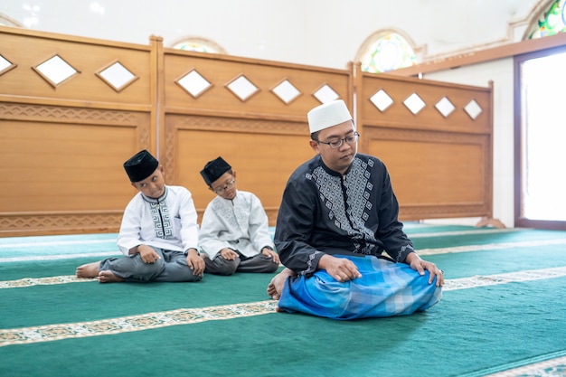 Padre e hijo rezando juntos en la mezquita