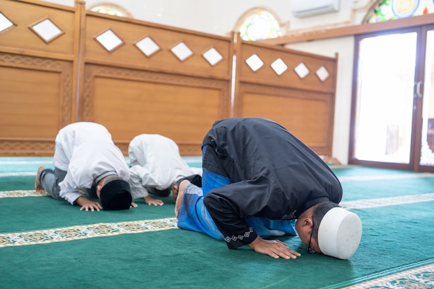 Padre e hijo rezando juntos en la mezquita