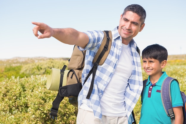 Padre e hijo, senderismo en las montañas en un día soleado