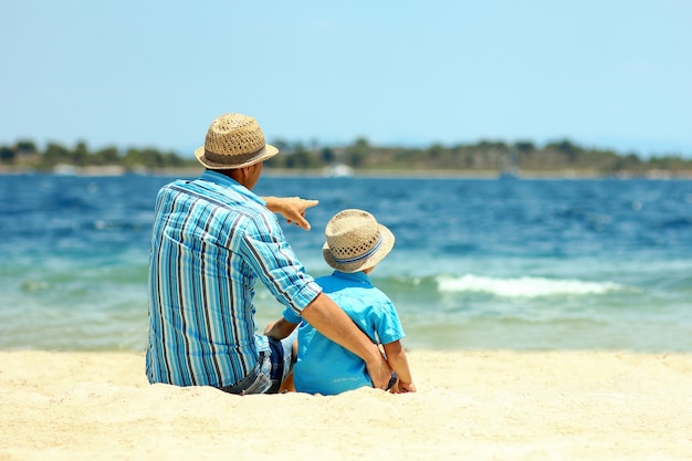 Padre e hijo se sientan junto al mar y sueñan