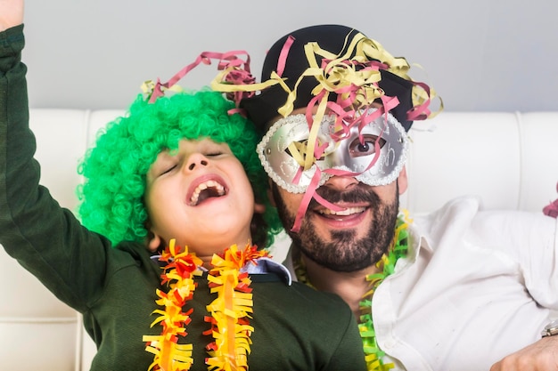 Padre e hijo con sopladores de cuerno de fiesta disfrutando en casa