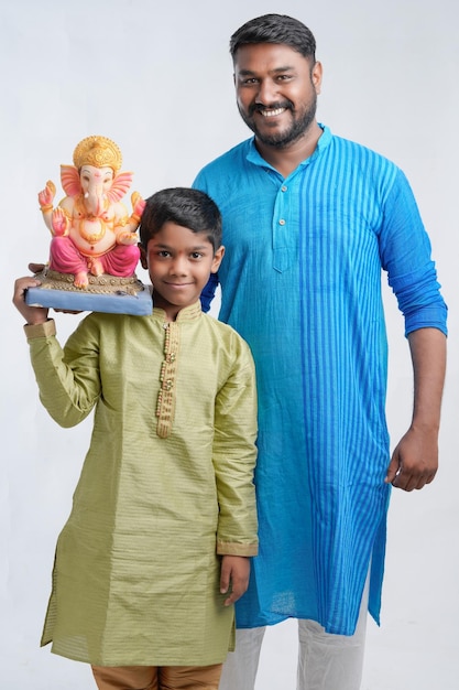 Padre e hijo sosteniendo un ídolo del señor Ganesha