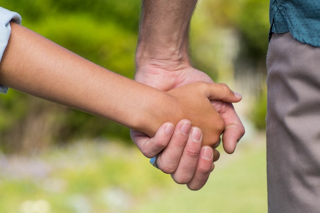 Foto padre e hijo tomados de la mano