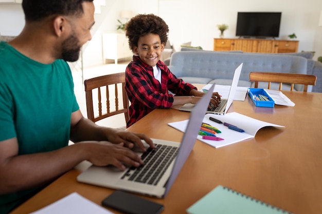 Padre e hijo usando una computadora portátil en casa