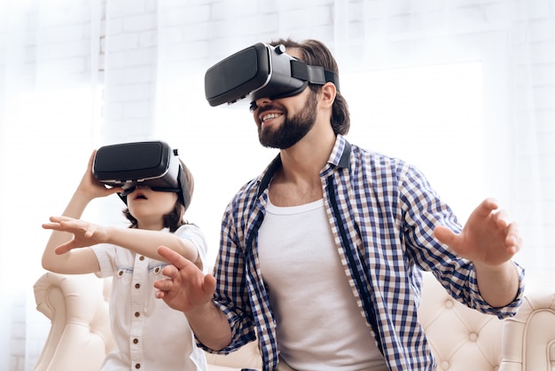 Padre e hijo, usando gafas de realidad virtual, juegan en el juego.