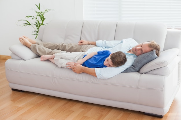 Padre e hijo usando siesta en el sofá