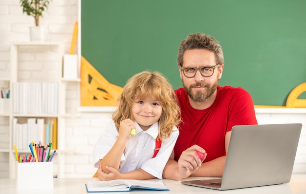 Padre e hijo utilizan tecnología de comunicación moderna. blog familiar. infancia y paternidad. niño feliz estudia con profesor privado. lección en video del seminario web. educación en línea en la computadora portátil.